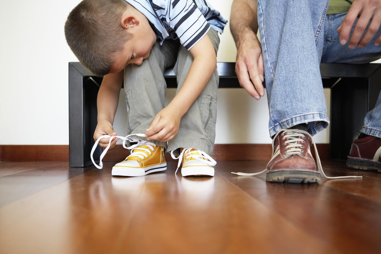 Ребенок учится завязывать шнурки